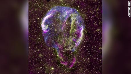 Приказана је радио (љубичаста), УВ (жута) и рендгенска (плава) слика остатка супернове Лабудовог прстена у Млечном путу. 
