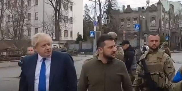 Са леве стране, премијер Уједињеног Краљевства и украјински председник Володимир Зеленски шетају улицама Кијева. 