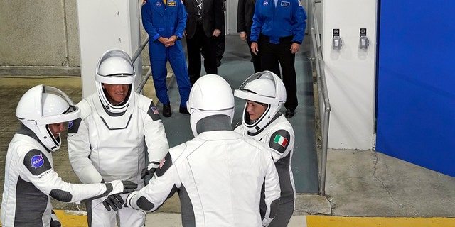 Астронаути СпацеКс Црев-4, лево, специјалиста за мисију Џесика Воткинс, пилот Боб Хајнс, командант Кјел Линдгрен и специјалиста мисије ЕСА астронаут Саманта Кристофорети из Италије, окупљају се након што су напустили оперативну зграду и погон за лет до комплекса за лансирање. 39- Среда, 27. априла 2022. године, у свемирском центру Кенеди у Кејп Канавералу на Флориди.