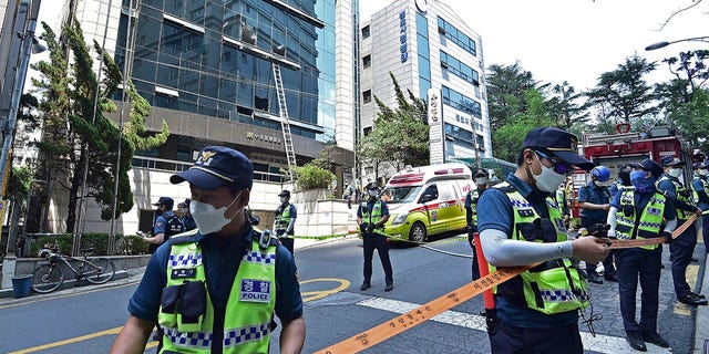 Полицајци контролишу место пожара у Даегуу, у Јужној Кореји, у четвртак, 9. јуна 2022. Неколико људи је погинуло, а више десетина повређено у четвртак у пожару који је избио у пословној згради у јужнокорејском граду Даегу, локални пожар, рекли су полицијски званичници.  (Лее Му-иеол/Новости преко АП-а)