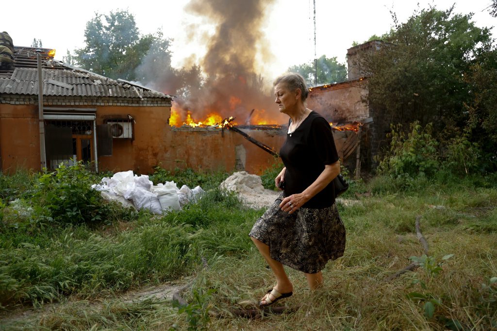 Жена бежи из куће која се запалила након бомбашког напада у Доњецку.