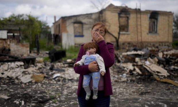 Нела Зеленска држи лутку која припада њеној унуци испред своје уништене куће у Поташњи, у близини Кијева, у Украјини, у мају.