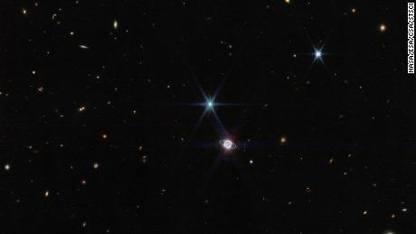 На овој фотографији Веб & # 39;  с Блиска инфрацрвена камера, мала група од стотина позадинских галаксија, различите величине и облика, појављује се поред Нептуна.