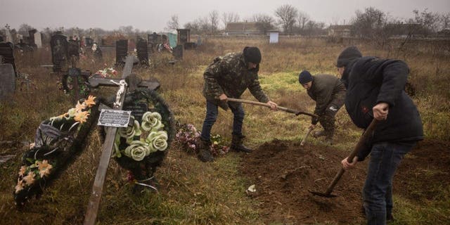 Становници и званичници Украјине ексхумирају тело 16-годишње девојчице и још седам мушкараца које су руске снаге убиле и сахраниле у граду Правдин, на периферији Херсона, 29. новембра 2022. године.