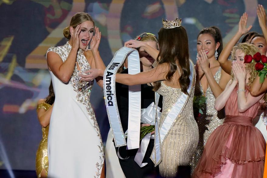 Госпођица Висконсин Грејс Станк, лево, прима свој шал за Мисс Америке 2023 од Еме Бројлс за Мисс Америке 2022