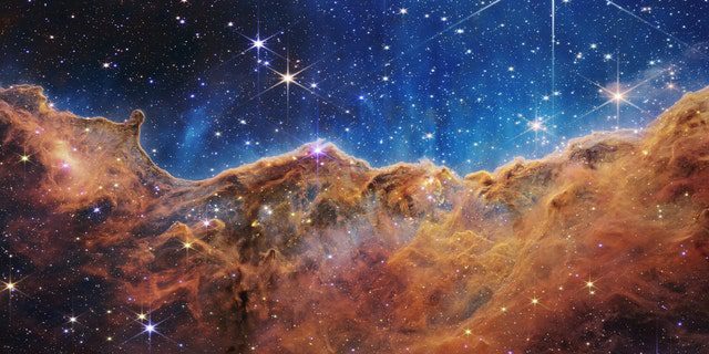 Оно што много личи на стеновите планине у вече обасјано месечином је заправо ивица оближњег, младог региона за формирање звезда НГЦ 3324 у маглини Карина.  Снимљена у инфрацрвеном светлу блиском инфрацрвеном камером (НИРЦам) на НАСА-ином свемирском телескопу Џејмс Веб, ова слика открива раније затамњене регионе рођења звезда.